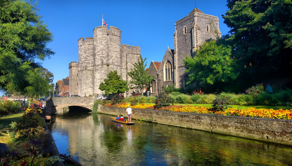 A view of the River Stour in sunshine with the Westgate Towers in the distance